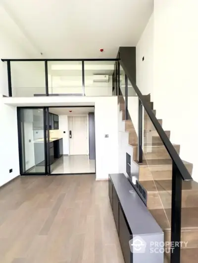 Modern duplex apartment with sleek staircase and open layout in a stylish urban setting.