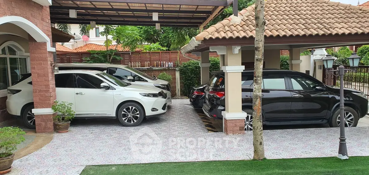 Spacious residential parking area with multiple cars and tiled driveway.