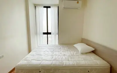 Bright bedroom with large window and air conditioning unit