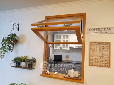 Charming kitchen with open window bar, modern cabinets, and cozy decor.