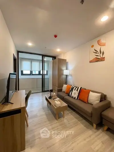 Modern living room with stylish decor and natural light, featuring a cozy sofa and sleek wooden furniture.