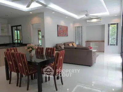 Spacious living room with modern dining area and cozy seating, perfect for family gatherings.