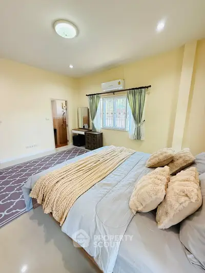 Spacious bedroom with cozy decor and natural light