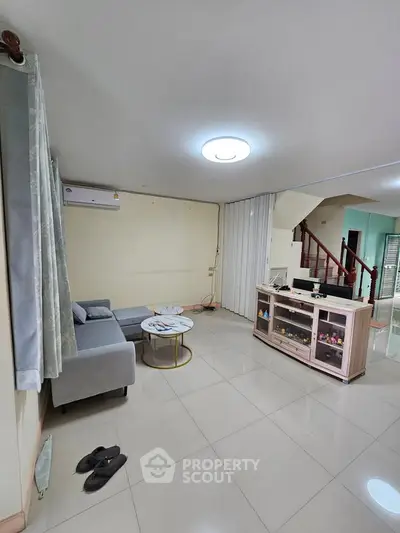Spacious living room with modern furniture and sleek tile flooring in a contemporary home.