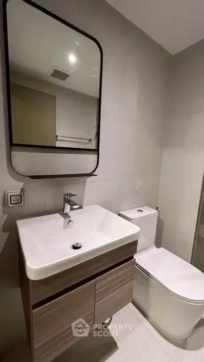 Modern bathroom with sleek vanity and mirror in contemporary apartment.
