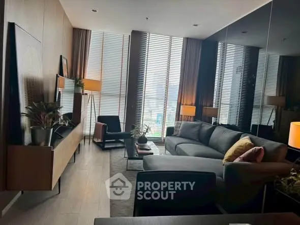 Luxurious modern living room with stylish furniture and floor-to-ceiling windows.