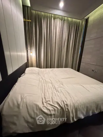 Cozy bedroom with elegant lighting and luxurious curtains, perfect for relaxation.