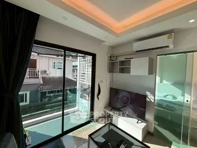 Modern living room with large window and sleek furniture