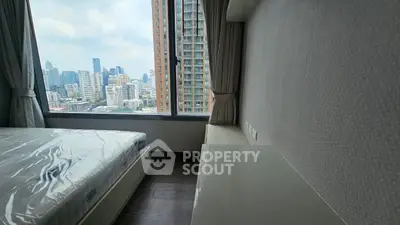 Modern bedroom with stunning city view and large window, featuring sleek design and natural light.