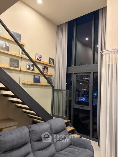 Modern duplex living room with high ceilings and stylish staircase