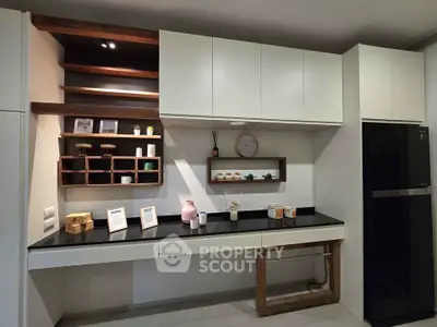 Modern kitchen with sleek cabinetry and stylish shelving, featuring a black countertop and contemporary decor.