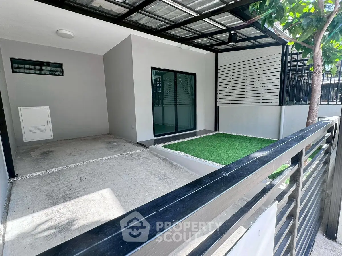 Modern home exterior with sleek design and artificial grass patio