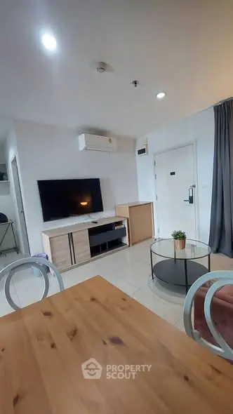 Modern living room with stylish furniture and wall-mounted TV in a cozy apartment.