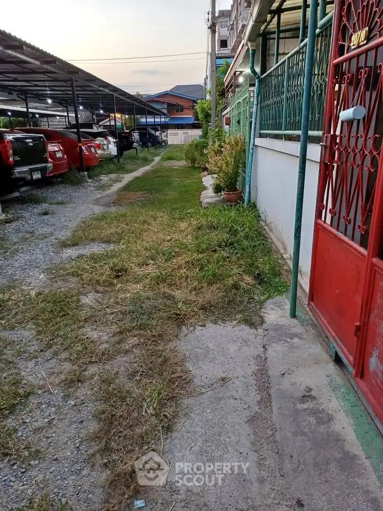 Charming residential exterior with garden path and parking area, perfect for urban living.