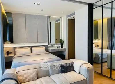 Modern bedroom with stylish decor and mirrored wardrobe in luxury apartment.