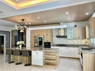 Luxurious modern kitchen with marble countertops and stylish lighting in a spacious open layout.