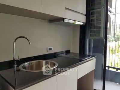 Modern kitchen with sleek black countertop and stainless steel sink
