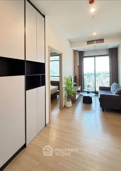 Modern living room with city view, featuring sleek furniture and large windows for natural light.