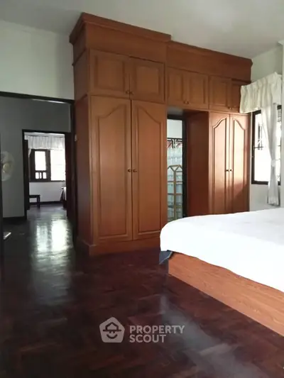 Spacious bedroom with elegant wooden wardrobe and polished hardwood floors