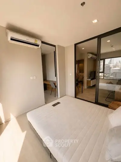Modern bedroom with large windows and city view, featuring minimalist decor and air conditioning.