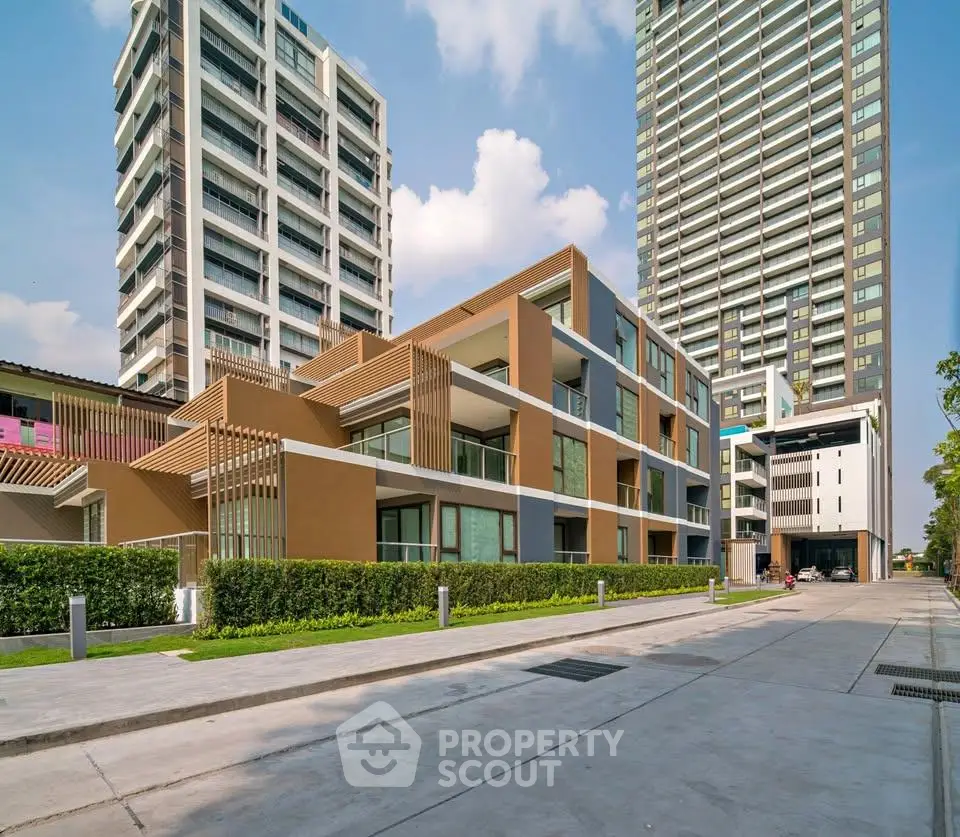 Modern urban apartment complex with sleek architecture and lush greenery.