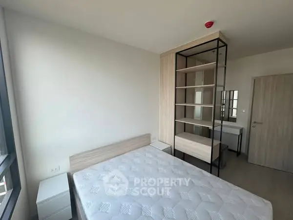 Modern bedroom with minimalist design and large window for natural light.