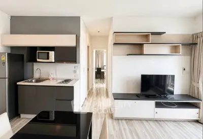 Modern open-layout kitchen and living room with sleek cabinetry and stylish shelving.