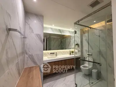 Luxurious modern bathroom with marble walls and glass shower enclosure