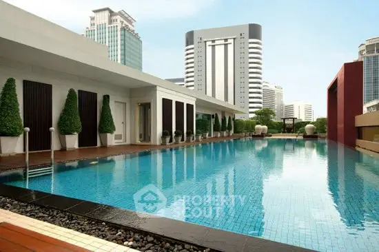 Luxurious rooftop pool with stunning cityscape views in a modern high-rise building.