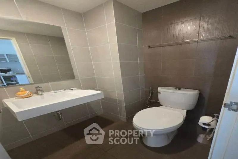 Modern bathroom with sleek fixtures and neutral tiles, perfect for a contemporary home.