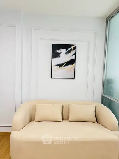 Modern living room with elegant beige sofa and abstract wall art, perfect for stylish urban living.