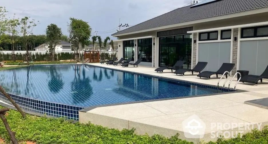 Luxurious outdoor pool area with modern sun loungers and lush greenery