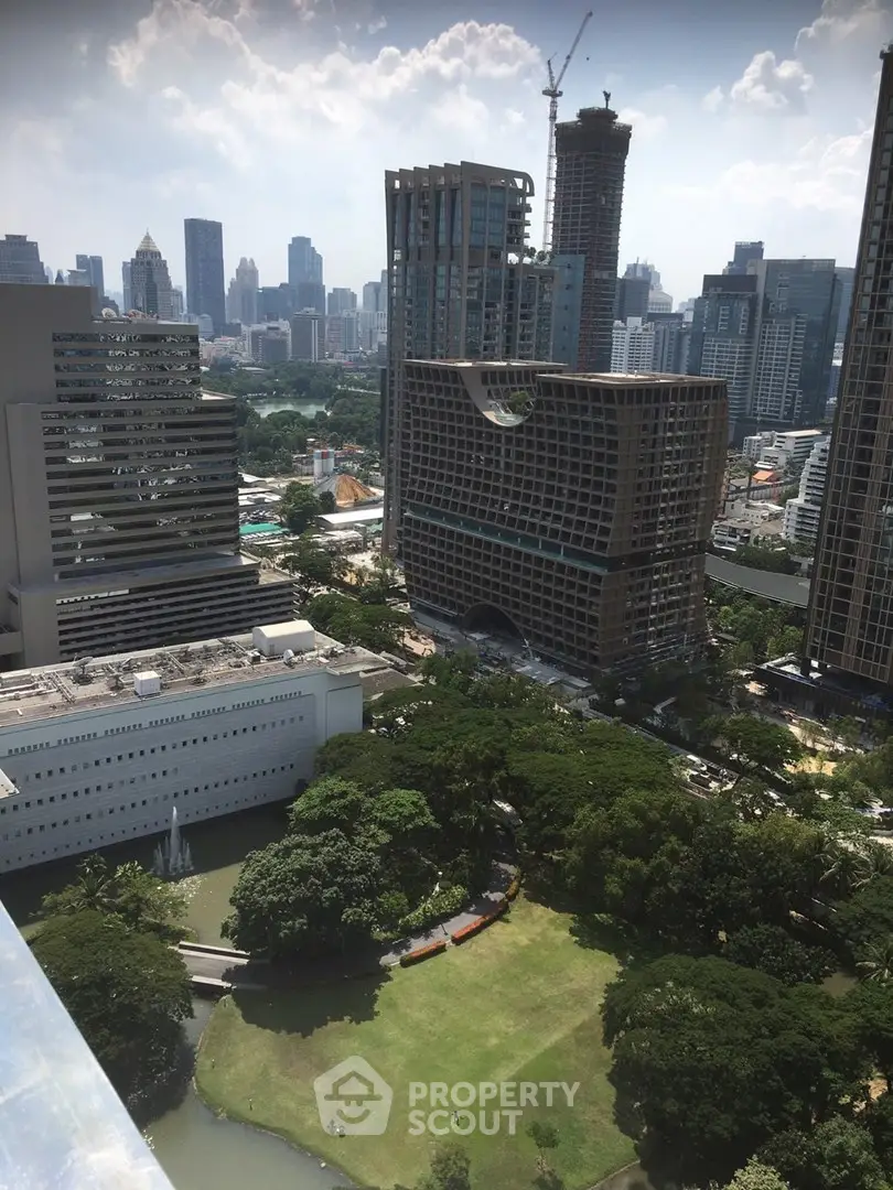 Stunning cityscape view from high-rise building overlooking lush park and modern skyline.