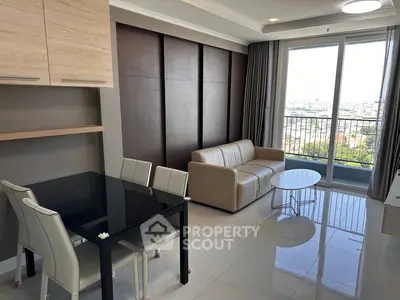 Modern living room with sleek furniture and city view balcony in high-rise apartment.