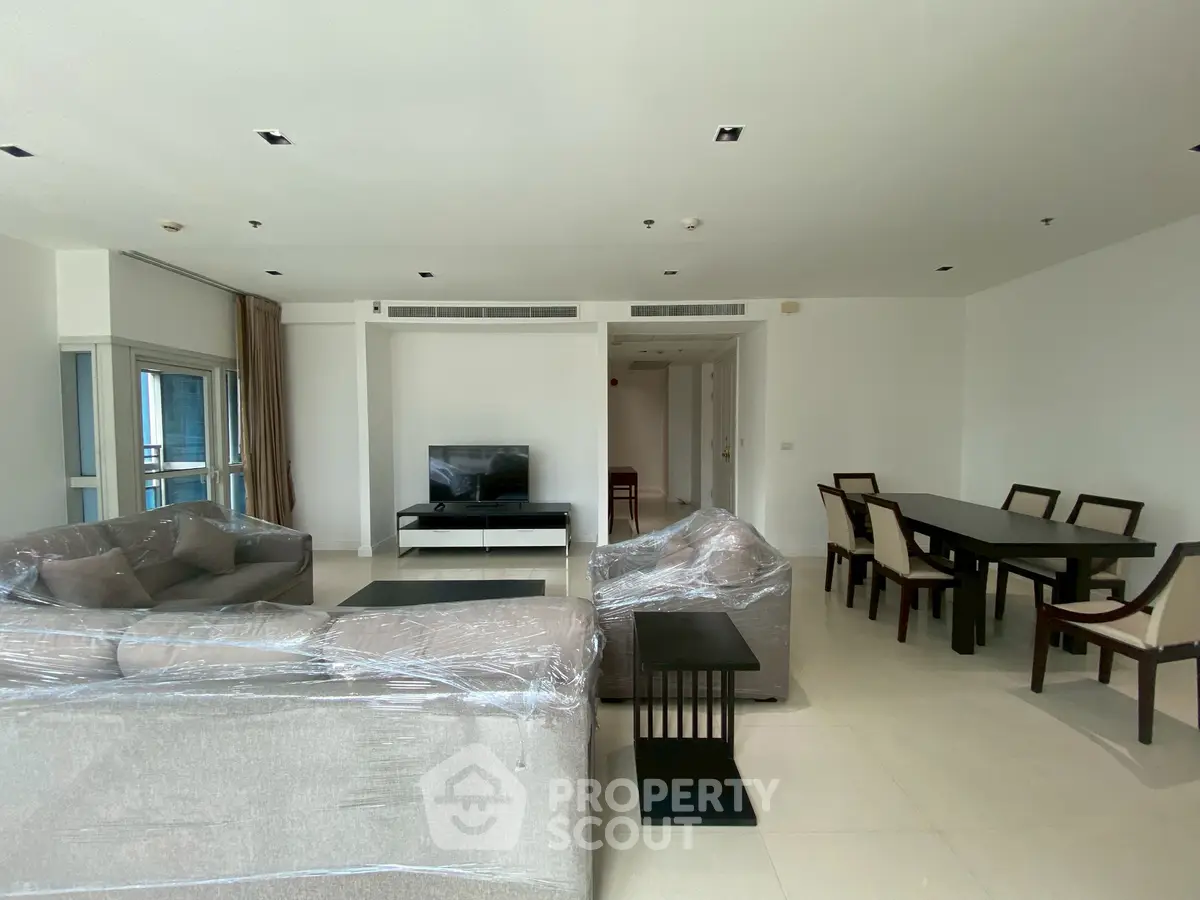 Spacious modern living room with elegant dining area and large windows for natural light.