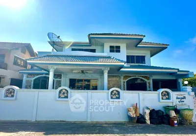 Charming two-story house with unique architectural design and spacious front yard.