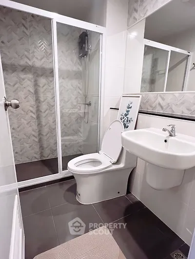 Modern bathroom with sleek shower and elegant fixtures in contemporary apartment.