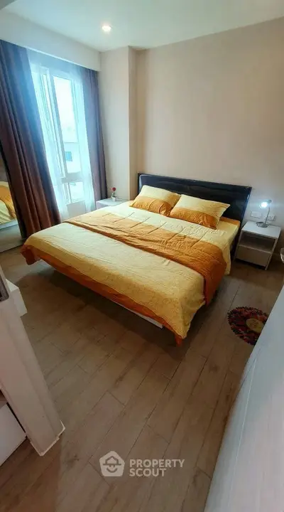 Cozy bedroom with large bed and natural light from window, perfect for relaxation.