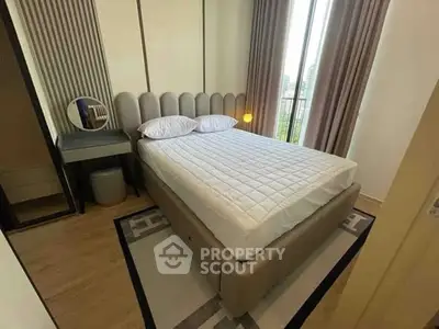 Modern bedroom with stylish decor and large window offering natural light