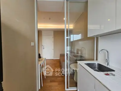 Modern compact kitchen with sleek cabinetry and open layout leading to cozy dining area.