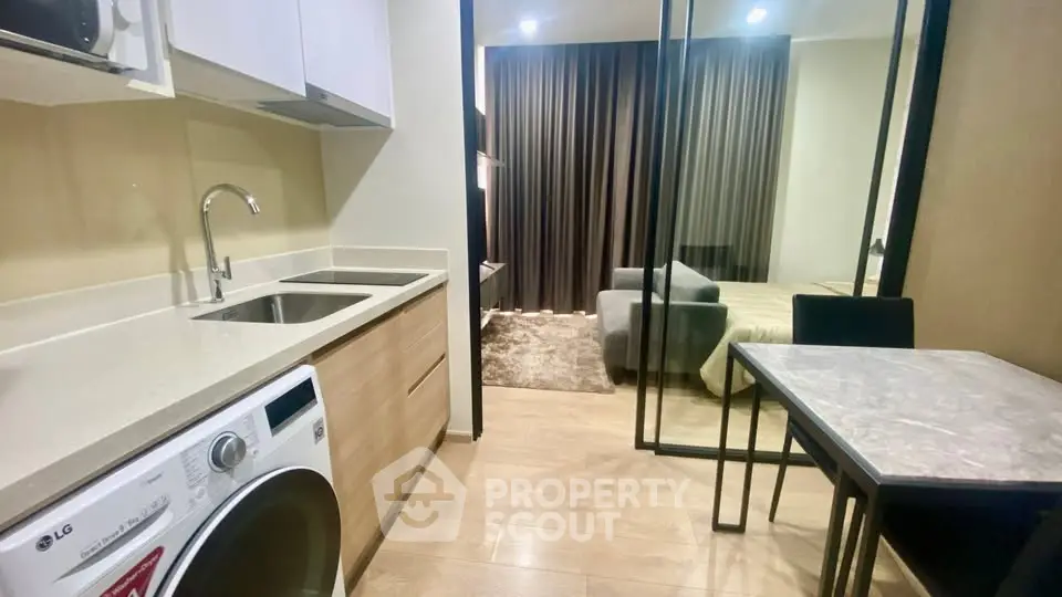 Modern studio apartment with sleek kitchen and cozy living area