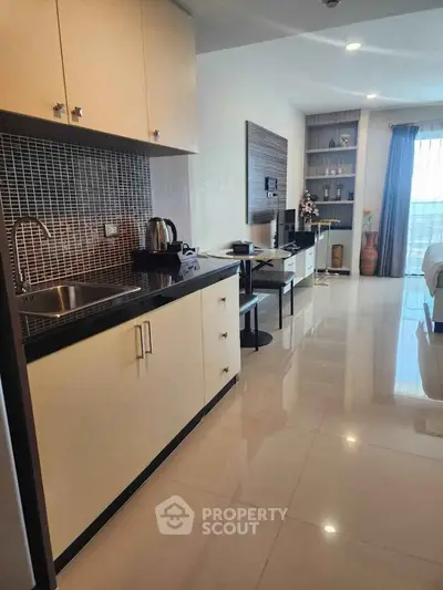 Modern studio apartment with sleek kitchen and cozy living area, perfect for urban living.