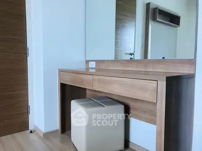 Modern bedroom with stylish wooden vanity and mirror, perfect for a chic and functional living space.