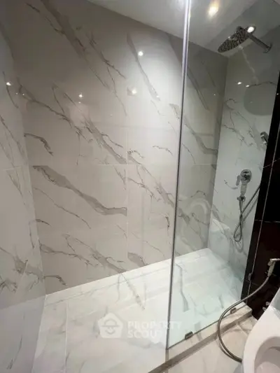Luxurious modern bathroom with elegant marble tiles and sleek shower design.