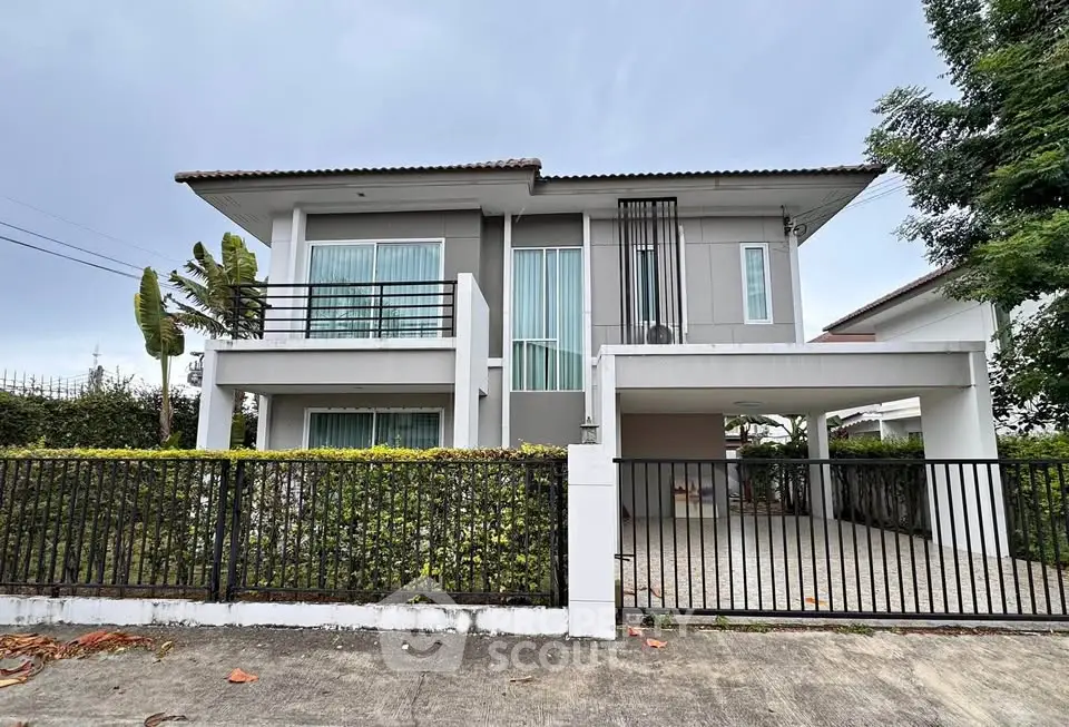 Modern two-story house with balcony and spacious driveway