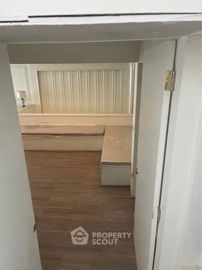 Cozy bedroom with wooden flooring and minimalist design, perfect for modern living.