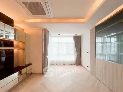 Spacious modern living room with elegant lighting and large windows.