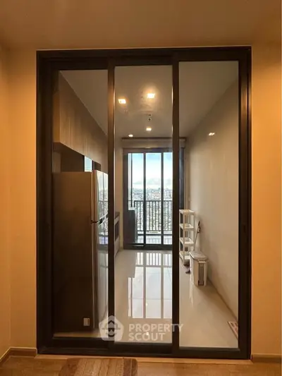 Modern apartment with sliding glass doors leading to a balcony with city view