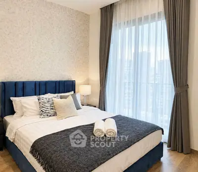 Luxurious bedroom with elegant decor and city view, featuring plush bedding and stylish curtains.