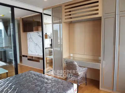 Modern bedroom with stylish built-in desk and large mirrored wardrobe in luxury apartment.